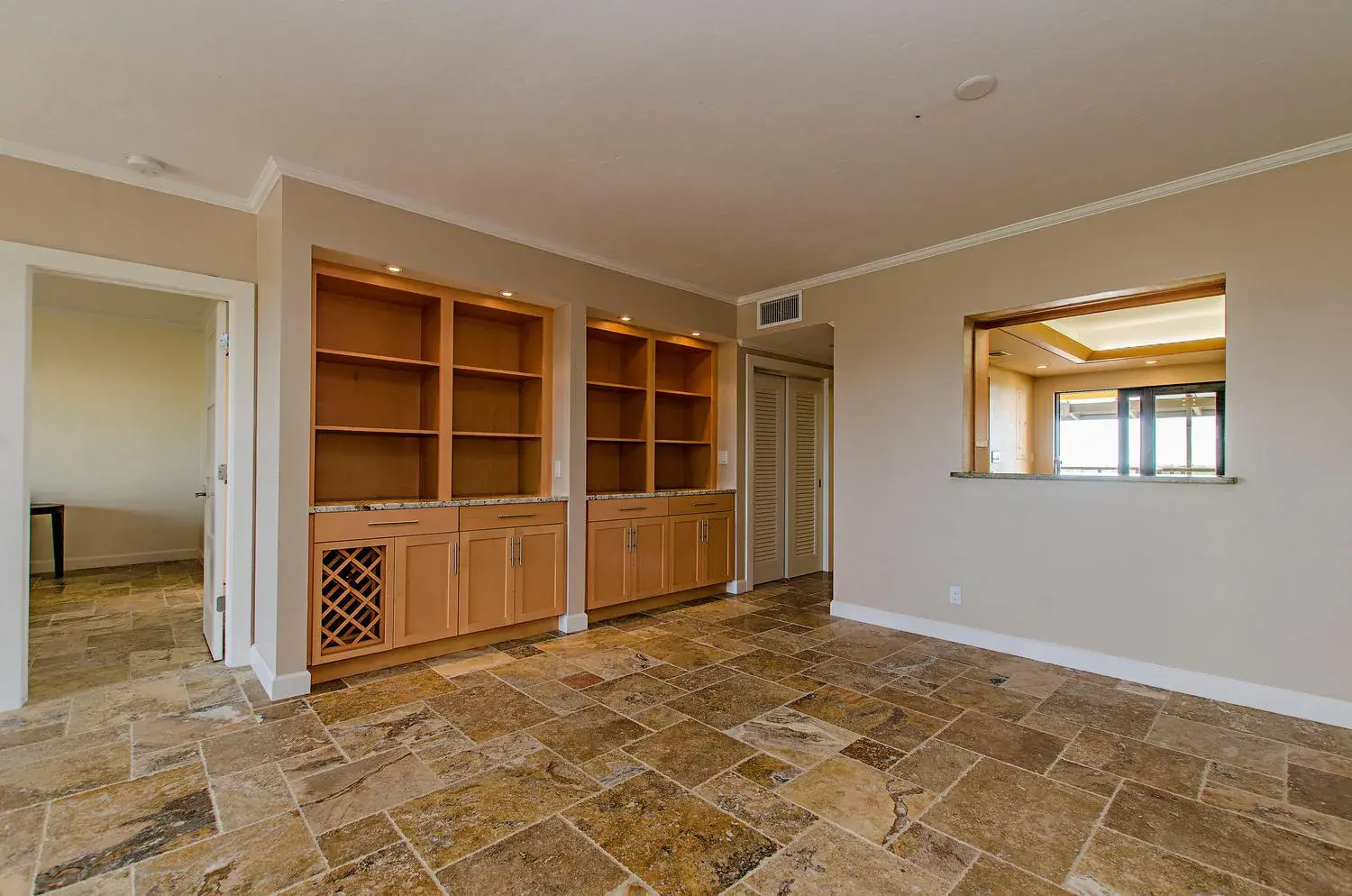 Completed Pelican Bay condo living room remodel with custom built-ins and wine storage